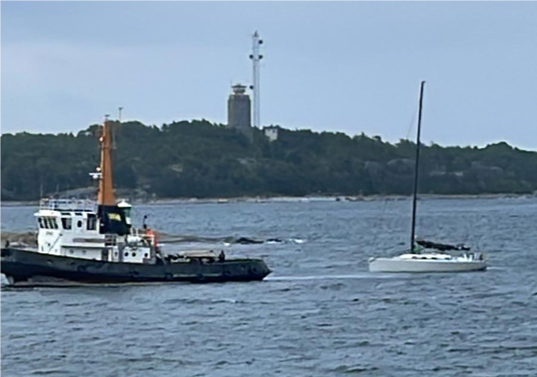 De två besättningsmännen undsattes med helikopter och båten lämnades stängd, med surrade segel och drivankare ute. När nu förhållandena lugnat ner sig kunde en bogserbåt genom båtens försäkringsbolag Svenska Sjö gå ut och bogsera in båten till Sandhamn. Förutom roderskadan är båten oskadad. Besättningen har kunnat vila upp sig och nu börjar reparationsarbetet. image001